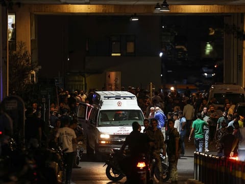 Ambulances are surrounded by people at the entrance of the American University of Beirut Medical Center after explosions hit locations in several Hezbollah strongholds around Lebanon.