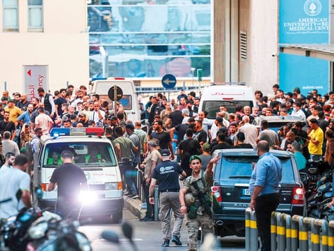 Ambulances are surrounded by people at the entrance of the American University of Beirut Medical Centre yesterday, after explosions hit several Hezbollah strongholds around Lebanon.