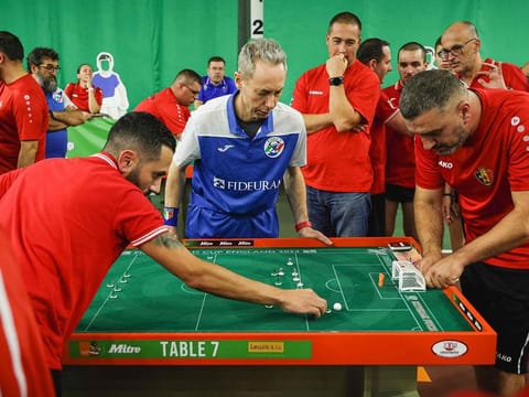 People watch the match as a player from Malta (L) prepares to take a shot against Belgium during the Subbuteo World Cup in Tunbridge Wells in south east England, on September 22, 2024. 