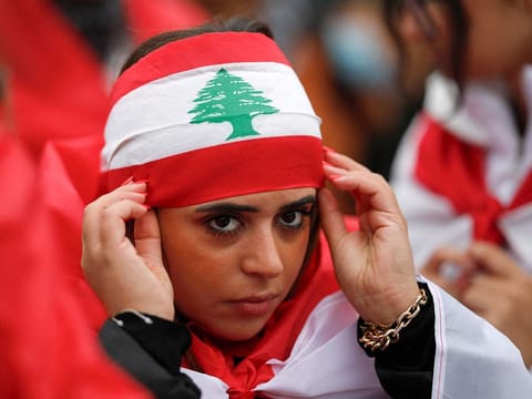 A protester wears a Lebanese flag during a demonstration in support of Lebanese people as intense Israeli attacks across Lebanon's east, south and on southern Beirut have killed hundreds of people and forced many to flee their homes, on Place de la Republique, in Paris, on September 29, 2024. 