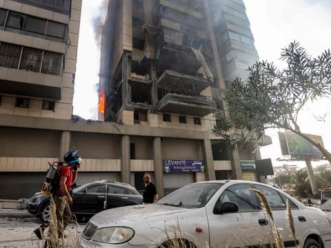 A Lebanese civil defence firefighter walks at the scene of an Israeli airstrike that targeted an apartment building in south Beirut Jnah neighbourhood on October 1, 2024.  