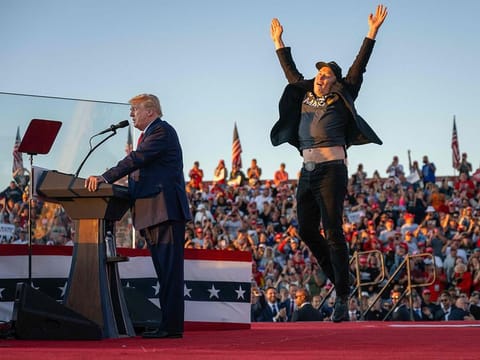 Tesla CEO Elon Musk (R) jumps on stage as he joins former US President and Republican presidential candidate Donald Trump during a campaign rally at site of his first assassination attempt in Butler, Pennsylvania on October 5, 2024