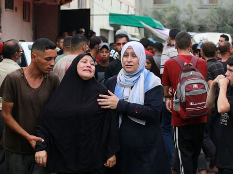 A women react upon identifying the bodies of victims of an Israeli strike that targeted a mosque-turned-shelter in Deir al-Balah in the central Gaza Strip, in the courtyard of the Al Aqsa Martyrs hospital on October 6, 2024, amid the ongoing war between Israel and the Palestinian Hamas movement. 