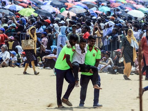 Fire and Rescue Service personnel evacuate a man after he fainted due to heat during the Indian Air Force (IAF) airshow as part of the 92nd anniversary celebrations of IAF, at Marina Beach in Chennai on Sunday.  