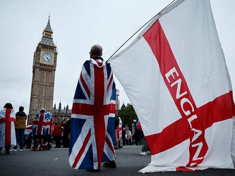 Supporters of Britain's notorious anti-Muslim agitator, Stephen Yaxley-Lennon, also known as Tommy Robinson gather in Parliament Square after a Uniting the Kingdom march through central London on October 26, 2024. 