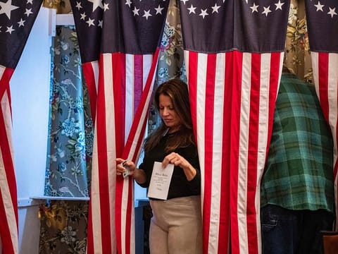 Residents of Dixville Notch cast their ballots in the US election at midnight in the living room of the Tillotson House at the Balsams Grand Resort, marking the first votes in the US election, in Dixville Notch, New Hampshire on November 5, 2024.  
