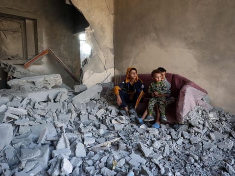 Children sit on a couch amid the destruction following an Israeli strike in Nuseirat in central Gaza on November 7, 2024