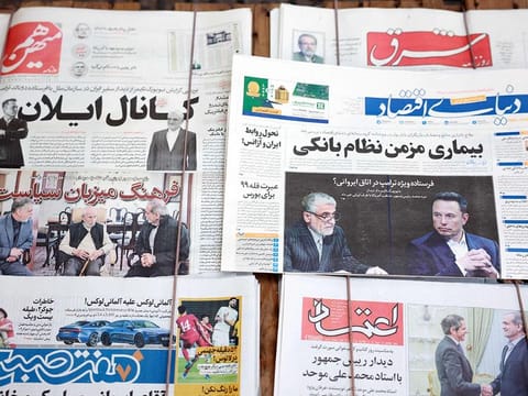 A picture taken at a news stand in Tehran on November 16, 2024 shows copies of Iran's Donyaye Eqtesad (C-R), Ham Mihan (top-L) and other daily newspapers with the main front-page headline highlighting the New York Times' report on a meeting between Tehran's ambassador to the United Nations Amir Saeid Iravani and tech billionaire Elon Musk earlier this week. 