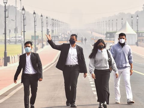 People wearing masks walk along Kartavya Path amid heavy smog as the air quality remains in the 'severe' category in New Delhi on Wednesday, November 20, 2024. 