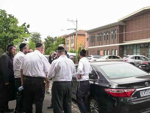 Members of the Jewish community gather near the scene of a fire at the Adass Israel Synagogue in Melbourne on December 6, 2024. 