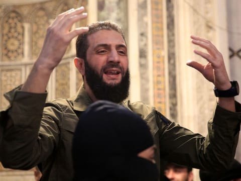 The leader of Syria's Islamist Hayat Tahrir Al Sham (HTS) group that headed a lightning rebel offensive snatching Damascus from government control, Abu Mohammed Al Jolani, addressses a crowd at the capital's landmark Umayyad Mosque on December 8, 2024.  