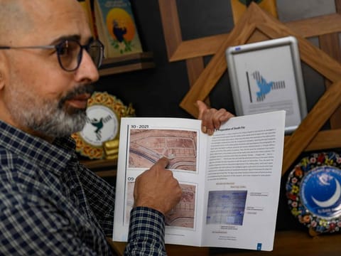 Riyad Avlar, who co-founded the Association of Detainees and Disappeared Persons of Saydnaya Prison (ADMSP), displays a research booklet about Saydnaya in Gaziantep, on December 11, 2024.  