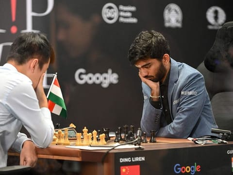 China's chess grandmaster Ding Liren (L) and India's grandmaster Gukesh Dommaraju (R) compete in game 14 of the 2024 FIDE World Championship in Singapore on December 12, 2024. 