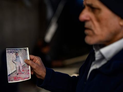 Mehmet Erturk, a Turk imprisoned in a Syrian prison, shows pictures during an interview with AFP journalists at his house in the village of Magaracik in Kilis on December 13, 2024.  
