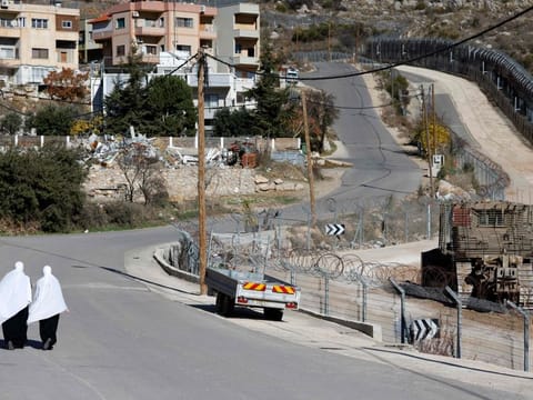 Druze women walk near the fence leading into the UN-patrolled buffer zone, which separates Israeli and Syrian forces on the Golan Heights, near the Druze village of Majdal Shams in the Israel-annexed Golan Heights on December 15, 2024.  