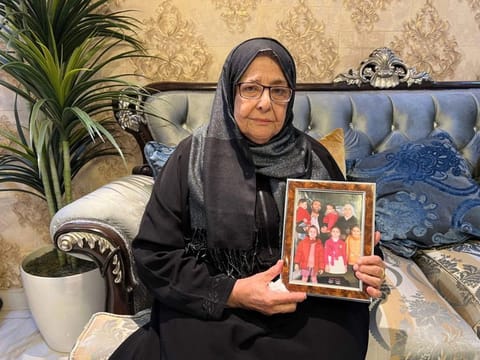 Najah Mardini, the mother of detained Syrian dentist and former national chess champion Rania Al Abassi, holds up a family picture of her daughter at her home in the Saudi capital Riyadh on December 12, 2024.  