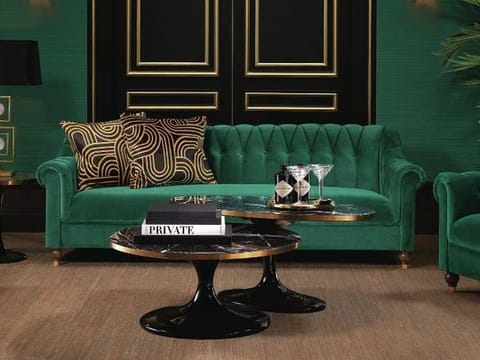 Go bold with monochromatic layers of Hunter Green, seen here grounded by a luxurious Eichholtz sofa